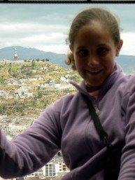My 15-year-old self leaning out of one of the towers of the Basilica Nacional in Quito, Ecuador, with the Panecillo in the background.